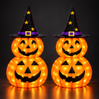 Two collapsible jack-o-lantern pumpkins with witch hats glowing with LED lights on a dark background