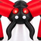 Close-up of the inflatable spider head with glowing red tunnel eyes, white eyes and curved black fangs