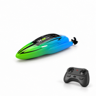 Mini RC speedboat with its remote controller on a white studio floor