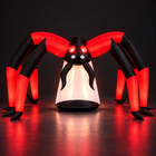 10ft red and black inflatable Halloween spider glowing at night with red eyes on a dark studio floor