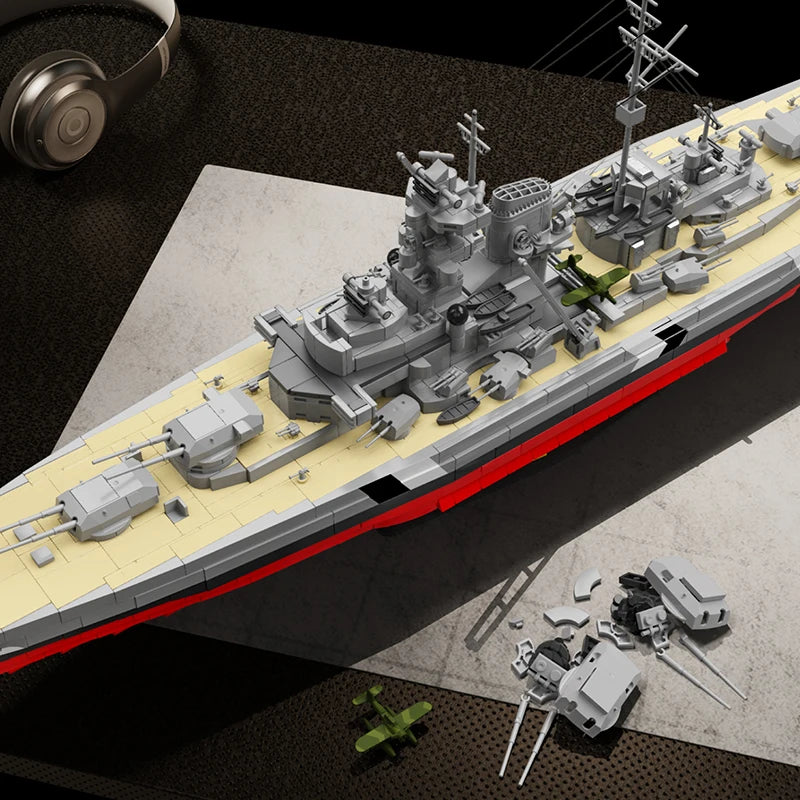 Top-angle view of the 2686PCS Bismarck Battleship building blocks kit showing detailed deck, turrets, and extra parts on the table.