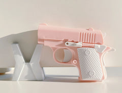 Toylvia Mini 1911 pink fidget toy gun displayed on stand – ABS plastic stress relief toy.