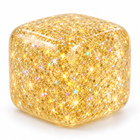 Translucent golden glitter ice cube squishy fidget on a clean white background.