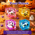 The 4 Halloween stress cubes stacked into a neat display pyramid on an office desk next to a keyboard.
