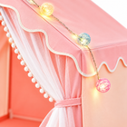 Close-up of the pink princess tent globe lights, scalloped canopy trim, and tied sheer mesh curtain.