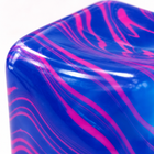 Close-up of the glossy cobalt-blue squishy cube with flowing magenta marble swirl lines.