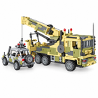 Rear three-quarter view of the tan military building-block crane truck and gray escort vehicle.