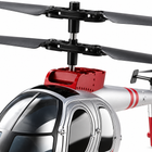 Macro detail of the silver and red RC helicopter's black coaxial rotor hub and red motor housing