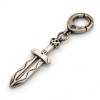 Retro skull holy sword pendant keychain in antique silver with spring clasp, lying on white surface