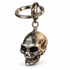 Three-quarter view of the vintage silver skull pendant keychain, connecting ring, and clasp on white.