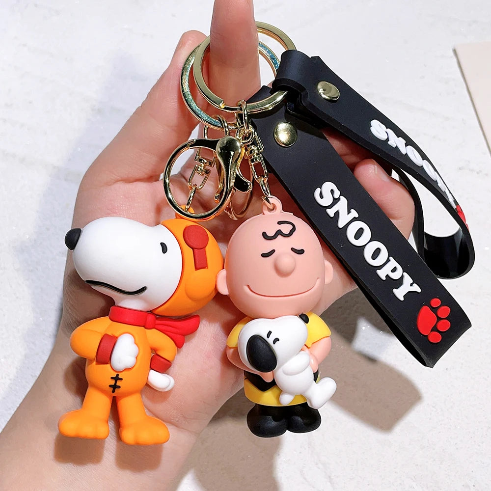 Snoopy and Charlie Brown silicone keychain with black strap held in hand