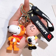 Snoopy and Charlie Brown silicone keychain with black strap held in hand