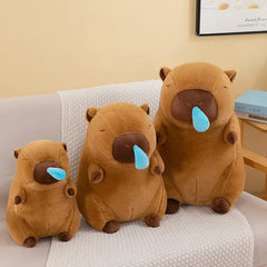 Three snot capybara plush toys in small, medium, and large sizes sitting on a sofa