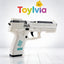 A sleek white toy pistol featuring teal accents and "Precision Shooting" text on the slide, shown in a studio setting with Toylvia branding
