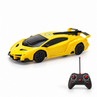 Yellow RC wall-climbing sports car with its remote controller on a white studio floor