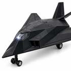 Close-up of the stealth jet toy cockpit, top activation button, faceted fuselage and illuminated nose LED.