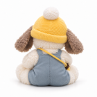 Plush puppy with yellow beanie, blue overalls and bee bag strap, back view