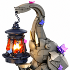 Close-up of grey brick elephant head, tusks, raised trunk and glowing lantern - Toylvia