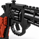 Close-up of the brick-built toy revolver showing studded cylinder, trigger guard and REVOLVER lettering