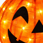 Close-up of the orange mesh fabric with LED lights and black felt jack-o-lantern face