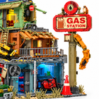 Close-up of the brick-built GAS STATION sign, claw arm, traffic cone and blue-lit garage with red motorbike
