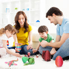 Hands holding open Easter dragon eggs and posing the colorful articulated mini dragons across a wooden tabletop.