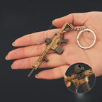 Mini M110 gold and black rifle keychain shown in a person's hand with size measurement