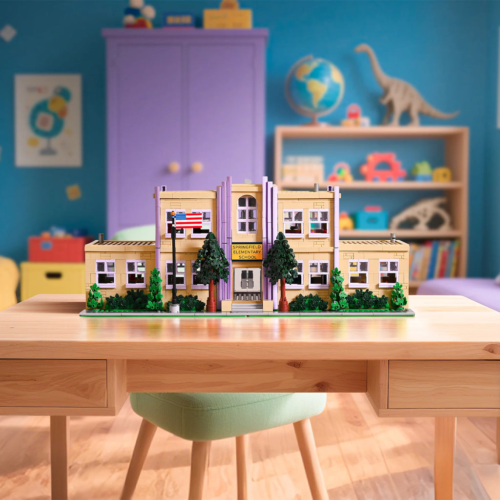 Model of a building on a desk with a colorful room in the background