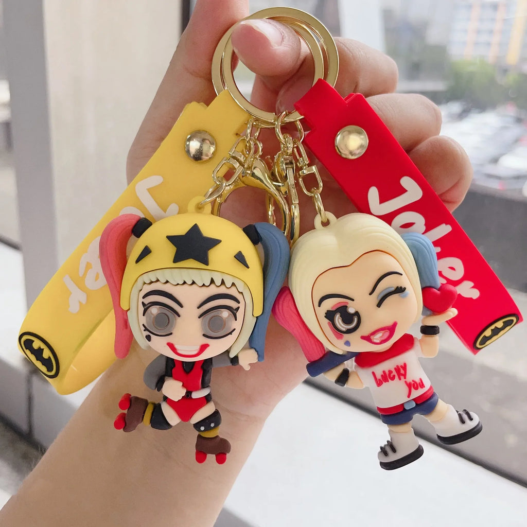 Two colorful cartoon-style girl character PVC keychains held in hand