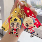 Two colorful cartoon-style girl character PVC keychains held in hand