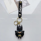 Cartoon-style hero-inspired PVC keychain with black strap on white background