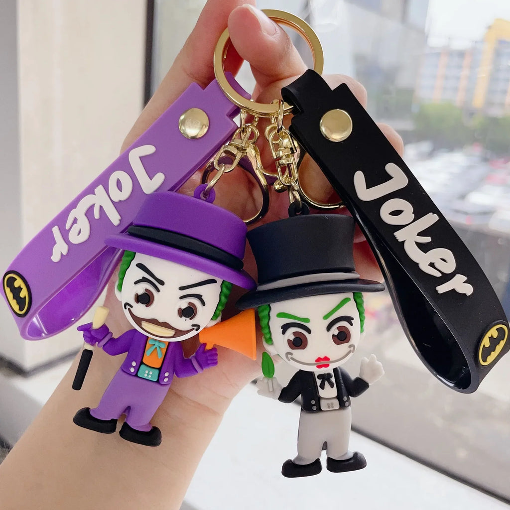Two cartoon-style villain character PVC keychains in purple and black colors