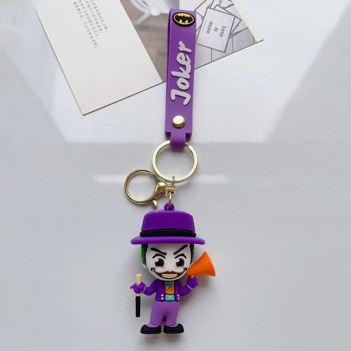 Cartoon-style villain PVC keychain in purple outfit on white background