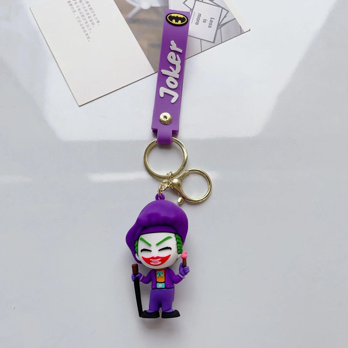 Cartoon-style villain-inspired PVC keychain with purple strap on white background