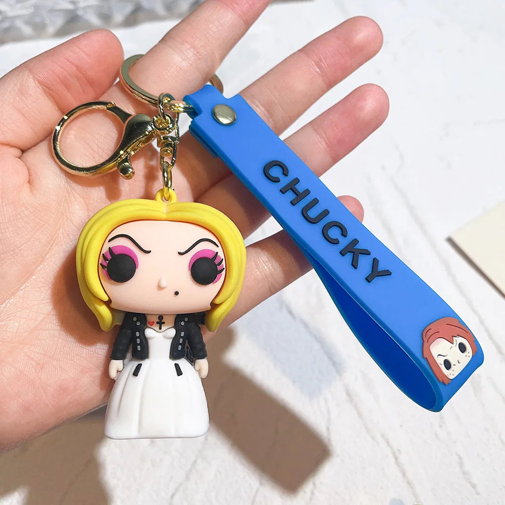 Chucky-style horror doll keychain with girl figure in white dress and blue strap