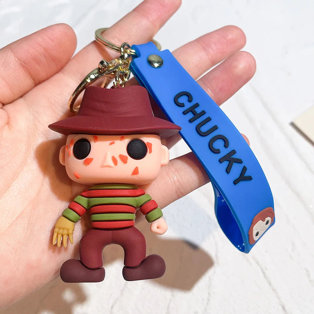 Chucky-style horror doll keychain wearing striped outfit and hat with blue strap