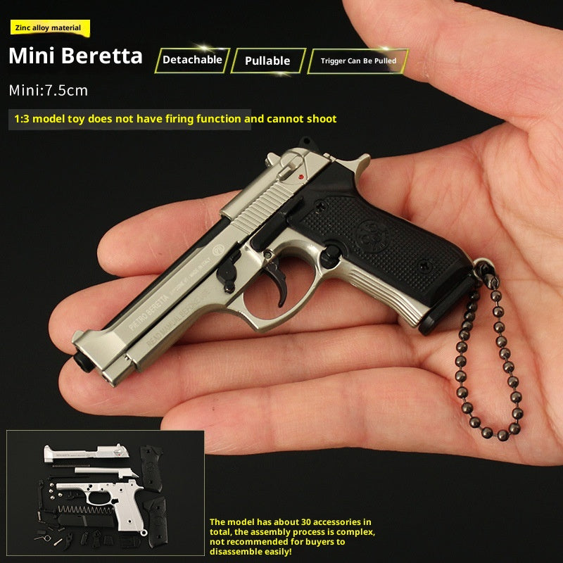 Miniature Beretta gun model held in a hand with product details on a black background
