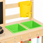 Close-up of yellow tap and green basins on wooden mud kitchen