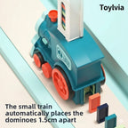 Top-down view of the small blue train automatically placing colorful dominoes exactly 1.5cm apart