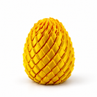 Yellow dragon egg fidget toy resting on a white surface with natural contact shadow