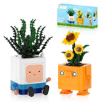 Two toy planters with faces, one green and one orange, next to a packaging box.