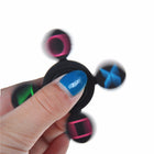 Hand holding the center cap of the fidget spinner between thumb and middle finger while flicking it with the index finger.