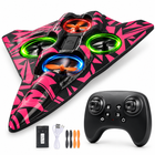 Pink and black EPP foam RC flying-wing airplane with matching black controller, battery, USB cable and spare propellers on white studio background.