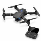 Dark gray folding FPV quadcopter with its matching phone-mounted remote at bottom right.