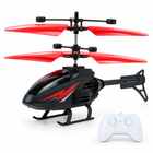 Red and black gesture-sensing RC helicopter with matching white two-button controller on a white studio background.