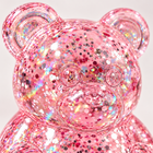Close-up of the clear pink bear squishy's molded face and colorful embedded glitter