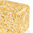 Macro detail of the translucent golden glitter cube squishy showing its sparkling gel texture.