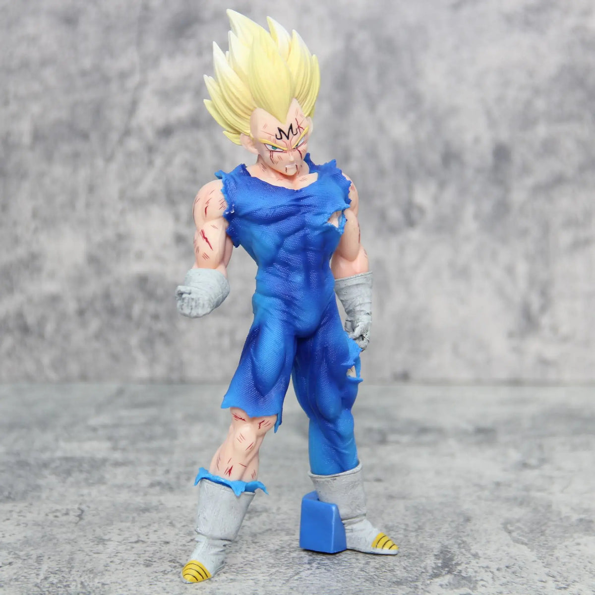 Majin Vegeta action figure angled front pose highlighting muscular build and battle-worn blue outfit on gray background