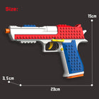 A toy gun-shaped building block set shown on a dark gray background with size annotations: 15 cm height, 23 cm width, 3.5 cm tip, and a total length marked as 23 cm.