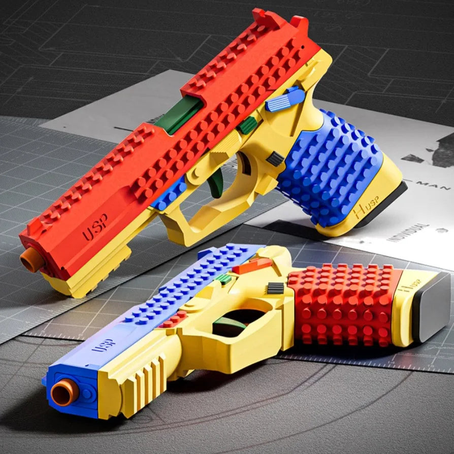 Toy gun made of interlocking bricks on a grid surface